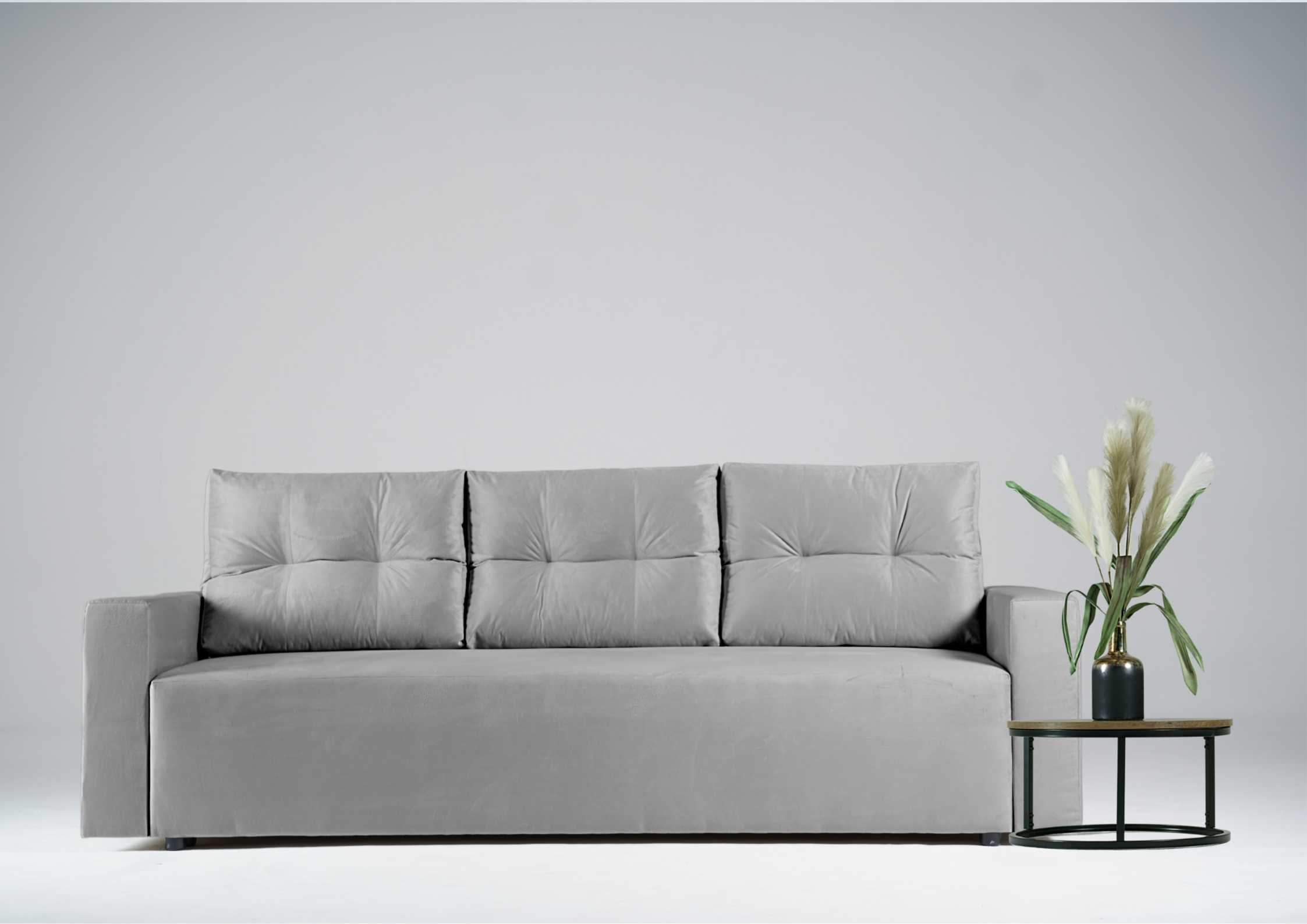 Szara kanapa z pikowanymi poduszkami